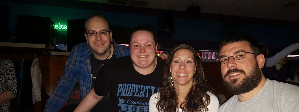 four people at bowling alley seats