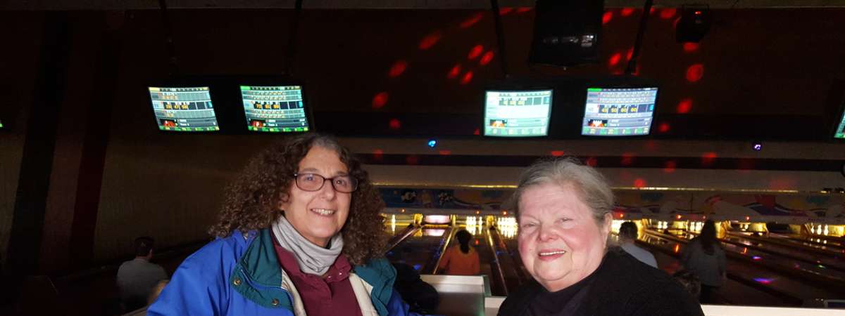 two people sitting together at a bowling alley