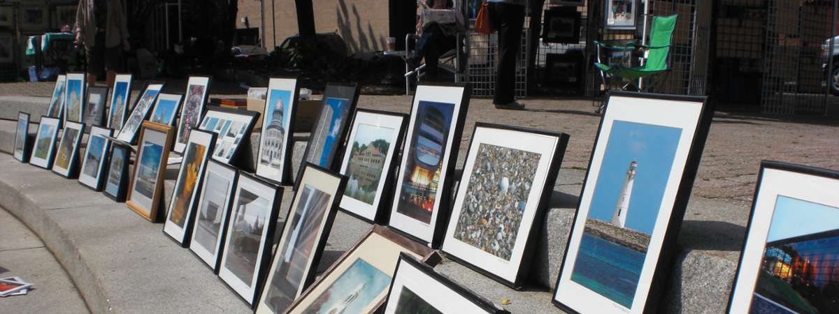 a lineup of framed pictures in the street