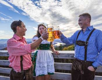 people dressed in oktoberfest attire cheersing