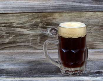 a dark beer in a glass mug