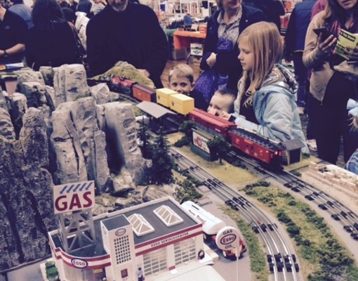 kids and people looking up close at a model train set