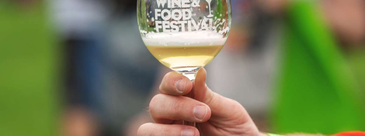 person holding an adirondack wine and food festival wine glass