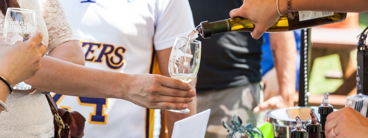 person pouring a wine sample