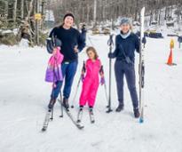 two women and a little girl pose in cross-country skis
