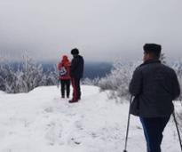 three people on mountain summit in winter