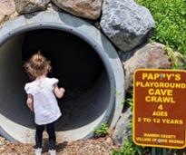 little girl going into a playground tunnel at a pappy's playground