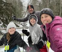 family of four pauses for a selfie while cross-country skiing