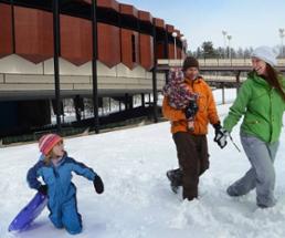 family in the snow by spac with sleds