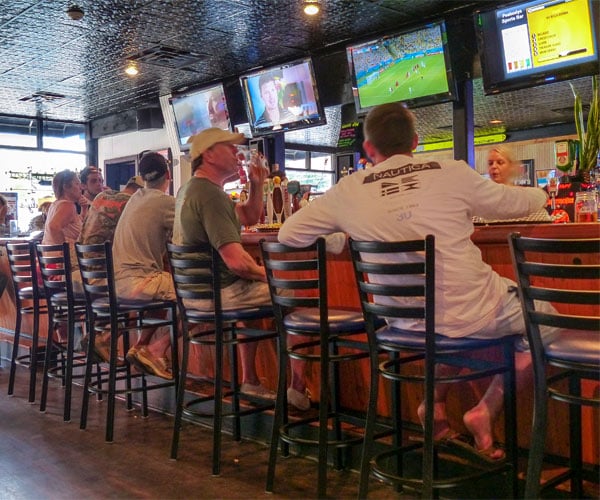 patrons at a sports bar watching tv