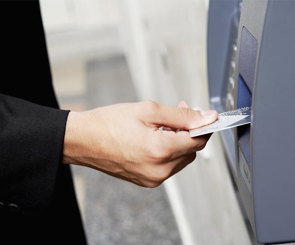 person using a debit card at an atm