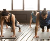 woman and man in a yoga class, plank pose