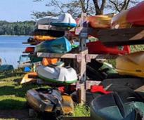 stacked kayaks in front of lake