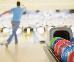 man throwing a bowling ball in bowling alley