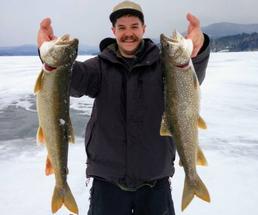 man holding up catch from ice fishing