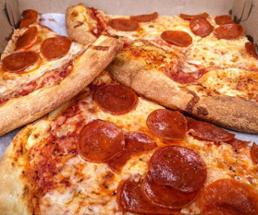 three slices of pepperoni pizza in a pizza box