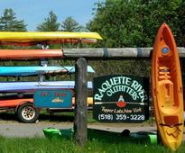 Raquette River Outfitters sign by kayaks