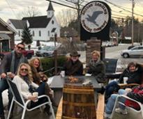 group at bolton landing brewing outside by fire