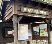 trailhead with register here sign