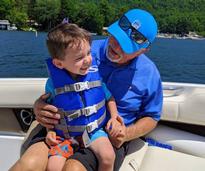 grandpa and grandson on a boat smiling