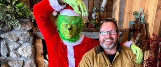 grinch poses with man