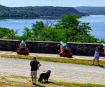 man with dog at fort ticonderoga near cannons and view of lake champlain