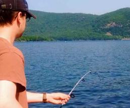 man with fishing pole at lake
