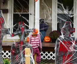 A house decorated with cobwebs and jack-o-laterns for Halloween.