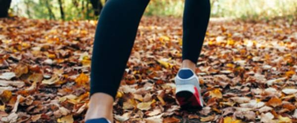 woman walking on fallen leaves