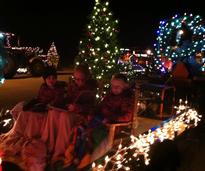 kids on a tractor with holiday lights