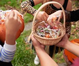 hands reach for candy in basket