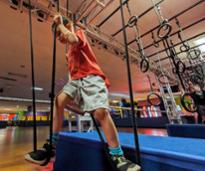 kid on rings course at indoor play place