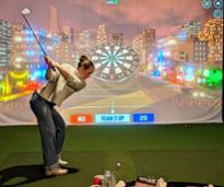 woman swings golf club at indoor simulator