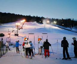 Skiiers approach the lift at West Mountain at night in Queensbury NY