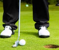 closeup of ball about to be putted into a hole