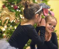 little girls dressed like mice by Christmas tree