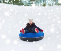 teenage girl smiling and snow tubing