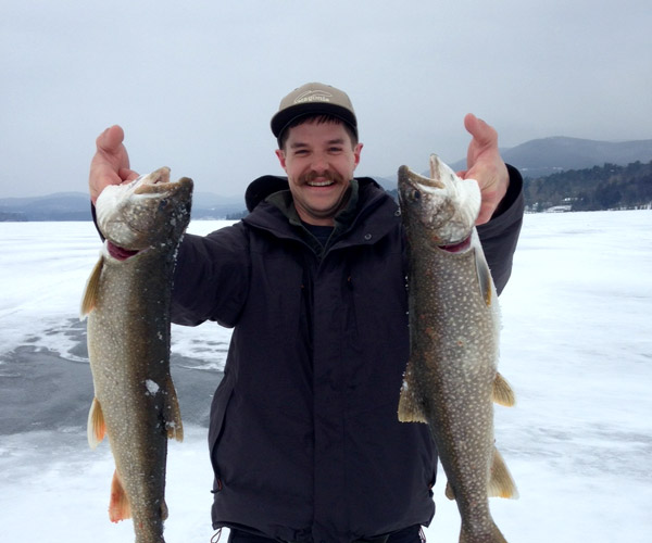 guy holding up fish on ice