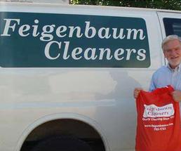 dry cleaner van and man holding laundry bag