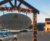 adirondack winery sign with part of winery in background, both lit up with holiday lights