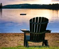 adirondack chair on a beach during sunset