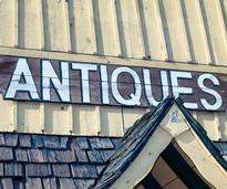 sign on a building that says "antiques"