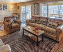 inside cabin-like living room with snow out the window