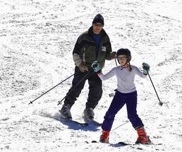 Father and daughter downhill skiing