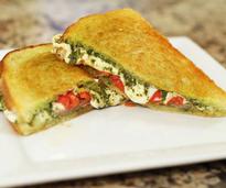 grilled cheese and pesto sandwich on a white plate