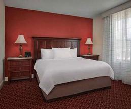 a hotel bedroom with white linens and a red wall