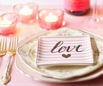 a plate with a napkin that says love, candles