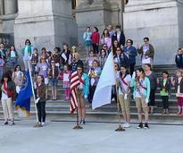 group of girl scouts having a ceremony on building steps