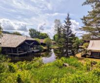 cabin structures and pond at adirondack experience museum