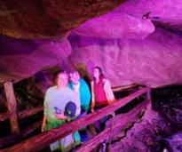 women walking in caves with purple light